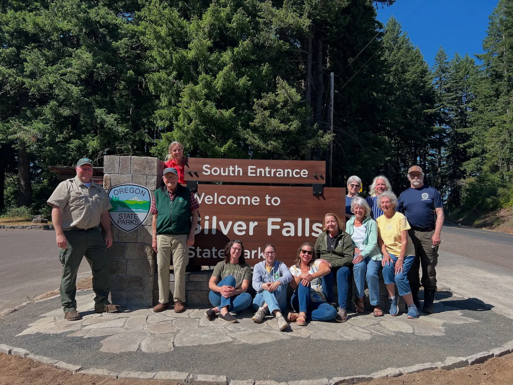 Friends of Silver Falls volunteers posing beside South Entrance sign