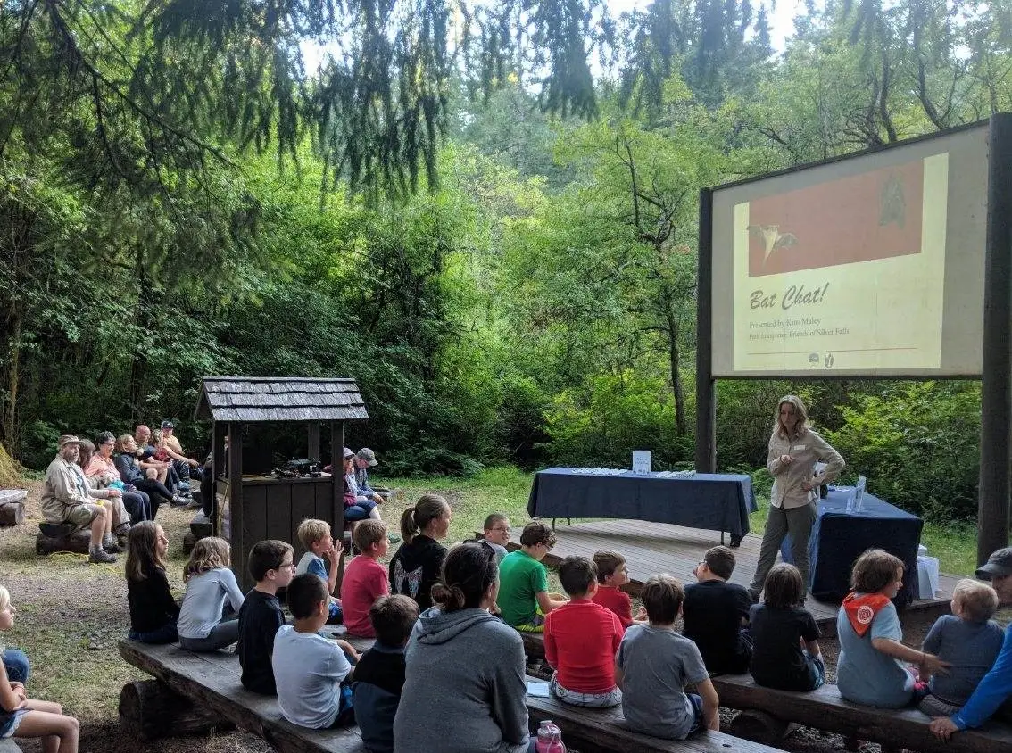 Families attending outdoor campground educational program at Silver Falls State Park amphitheater